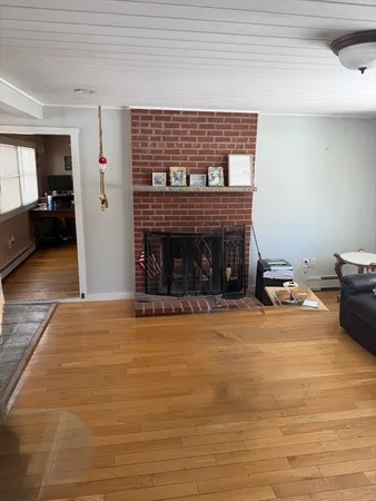 a view of empty room with wooden floor and fireplace