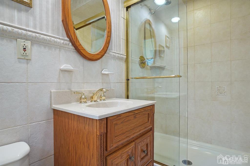 8 Tamarack Road Edison, NJ 08820 - Photo 14 of 31 a bathroom with a sink a toilet and a mirror