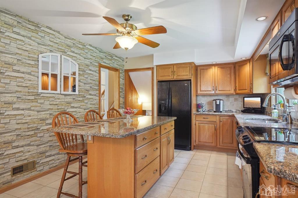 8 Tamarack Road Edison, NJ 08820 - Photo 7 of 31 a kitchen with stainless steel appliances granite countertop a sink a stove and a refrigerator