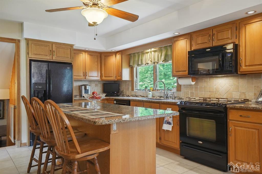 8 Tamarack Road Edison, NJ 08820 - Photo 8 of 31 a kitchen with stainless steel appliances granite countertop a stove top oven a sink a dining table and chairs