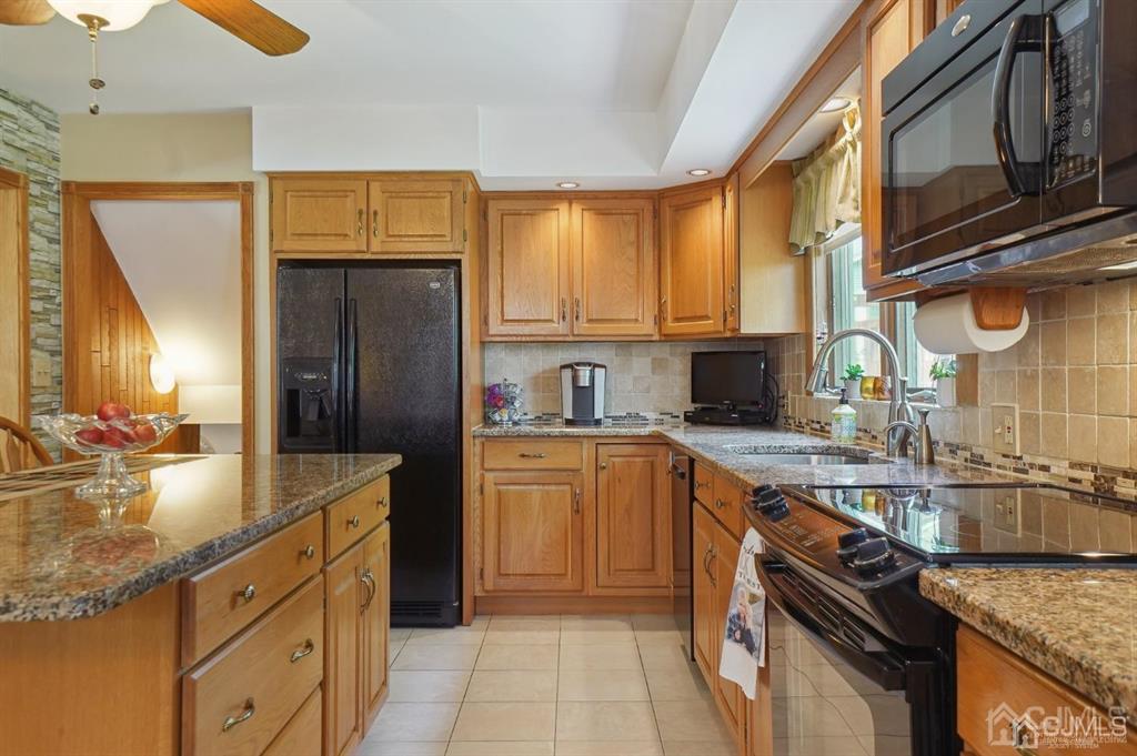 8 Tamarack Road Edison, NJ 08820 - Photo 9 of 31 a kitchen with stainless steel appliances granite countertop a sink stove and refrigerator