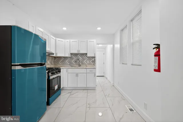 a kitchen with granite countertop a refrigerator and a sink