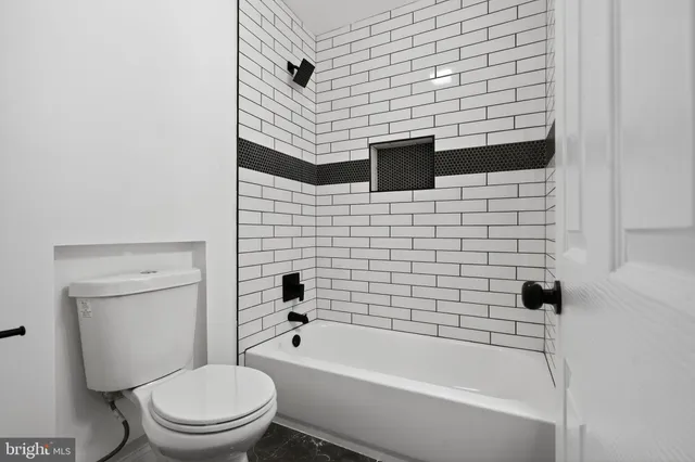 a bathroom with a toilet and a tub