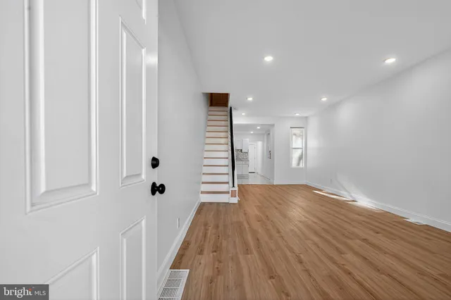 a view of a hallway with wooden floor and stairs