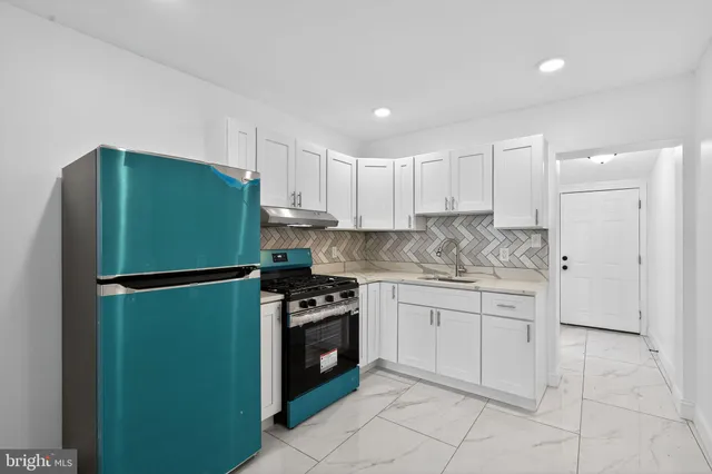a kitchen with stainless steel appliances granite countertop a refrigerator and a stove top oven