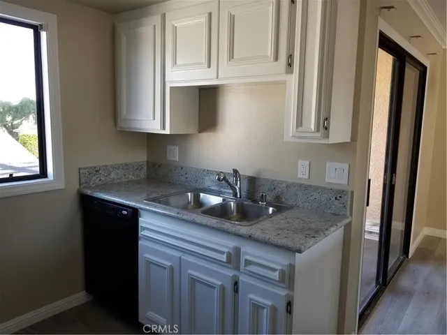 a kitchen with granite countertop a sink stove and cabinets