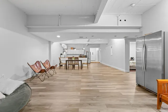a view of kitchen with stainless steel appliances furniture refrigerator dining table and chairs
