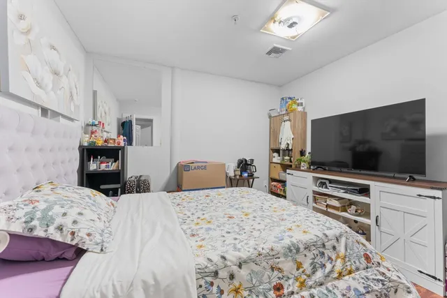 a bedroom with a bed and a flat screen tv