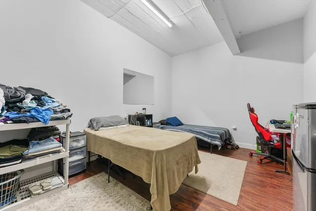 a bed room with a bed and a wooden floor