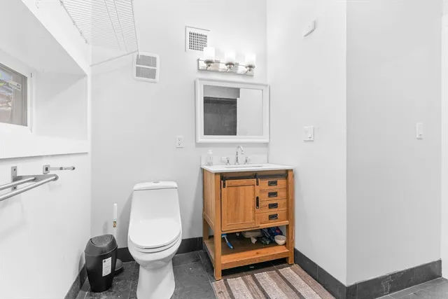 a bathroom with a toilet a sink and a mirror
