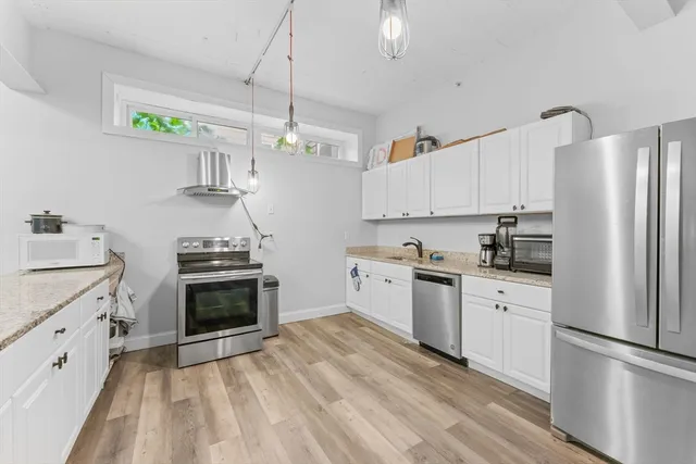 a kitchen with granite countertop a refrigerator stove and sink