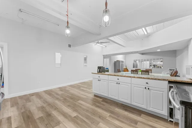 a kitchen with granite countertop a sink window and cabinets