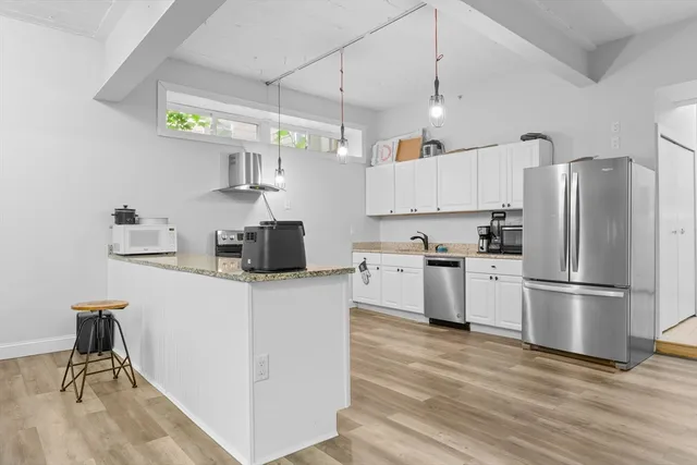 a kitchen with refrigerator cabinets and wooden floor