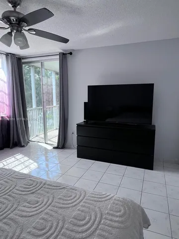 a living room with a black white checkered floor with a flat screen tv