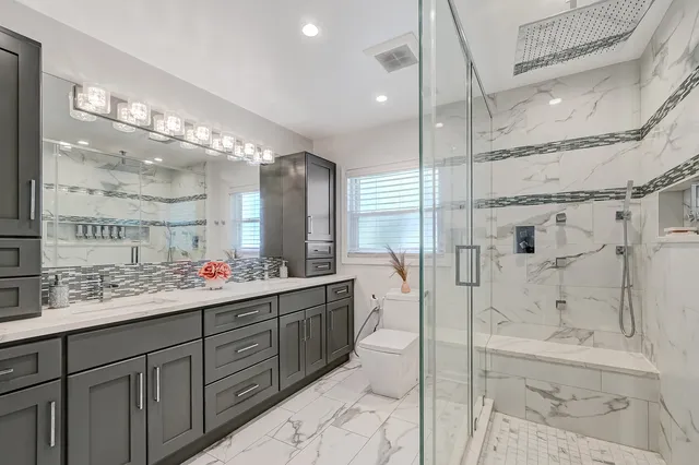 a bathroom with a double vanity sink mirror and shower