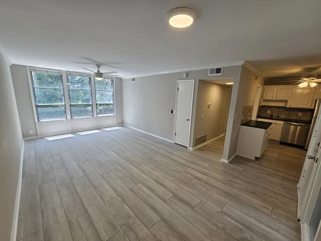 a view of an empty room with wooden floor