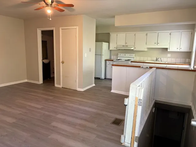 a kitchen with stainless steel appliances granite countertop a refrigerator a sink and white cabinets