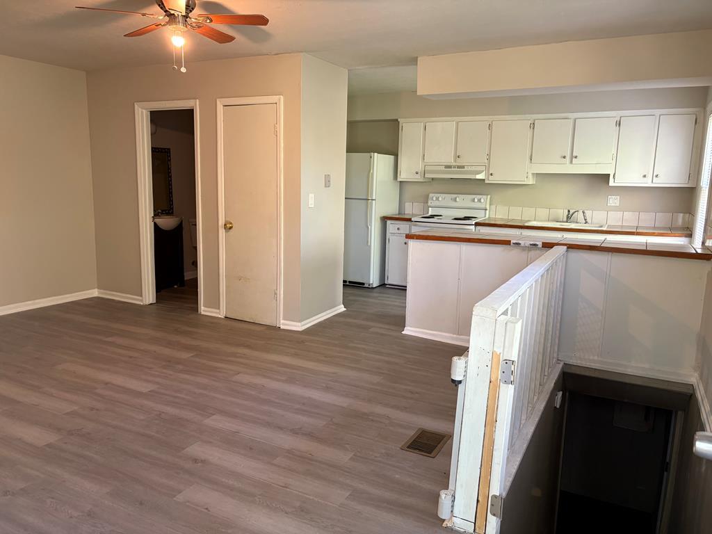 746 Fulton Avenue, Unit C Columbus, GA 31906 - Photo 2 of 5 a kitchen with stainless steel appliances granite countertop a refrigerator a sink and white cabinets