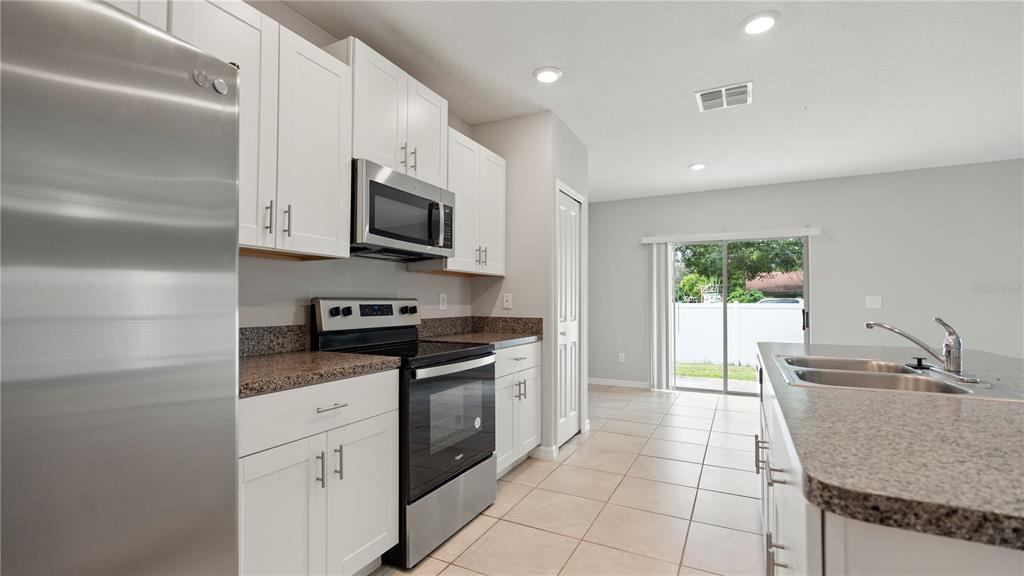 7231 Spring Snowflake Avenue Tampa, FL 33619 - Photo 13 of 46 a kitchen with stainless steel appliances granite countertop a sink and a stove