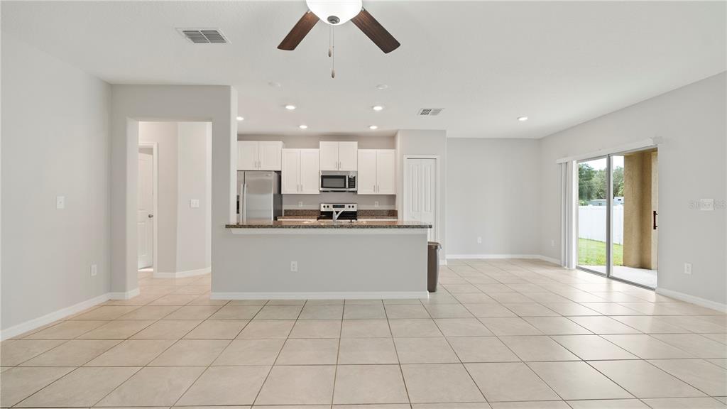 7231 Spring Snowflake Avenue Tampa, FL 33619 - Photo 14 of 46 a view of kitchen with stainless steel appliances kitchen island granite countertop a refrigerator and a sink