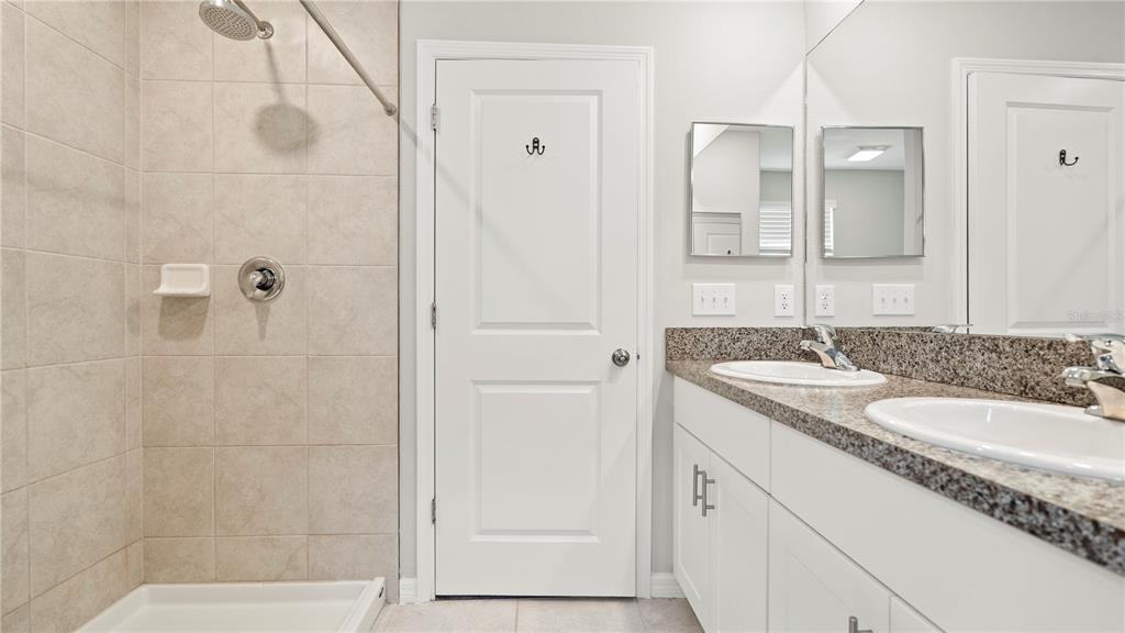 7231 Spring Snowflake Avenue Tampa, FL 33619 - Photo 26 of 46 a bathroom with a granite countertop sink and a mirror