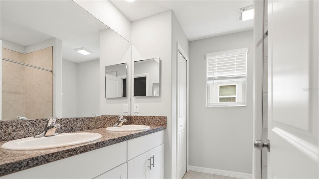 7231 Spring Snowflake Avenue Tampa, FL 33619 - Photo 27 of 46 a bathroom with a granite countertop sink and a mirror