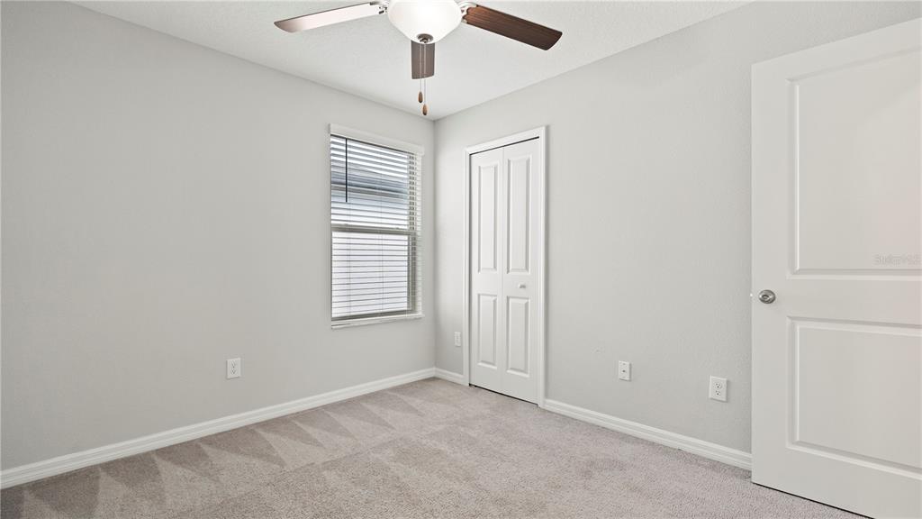 7231 Spring Snowflake Avenue Tampa, FL 33619 - Photo 31 of 46 en empty room with windows and ceiling fan