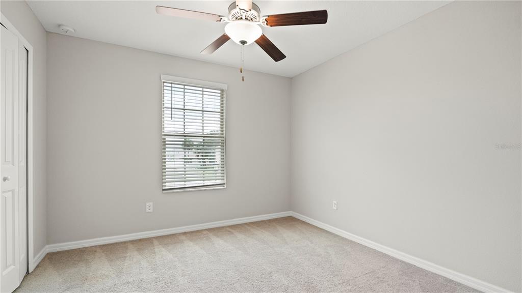 7231 Spring Snowflake Avenue Tampa, FL 33619 - Photo 40 of 46 an empty room with chandelier fan and windows