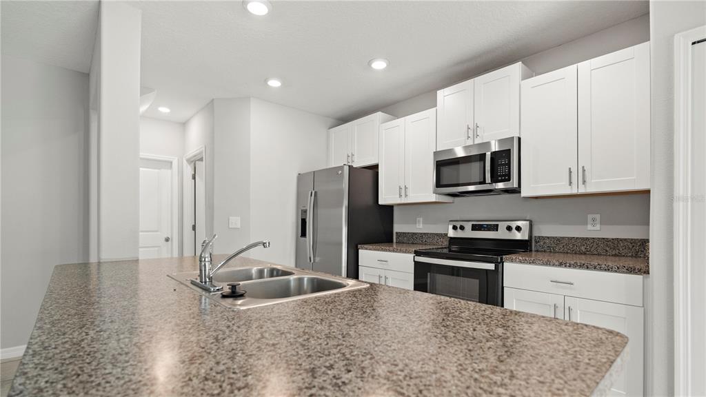 7231 Spring Snowflake Avenue Tampa, FL 33619 - Photo 8 of 46 a kitchen with stainless steel appliances granite countertop a stove a sink and a refrigerator