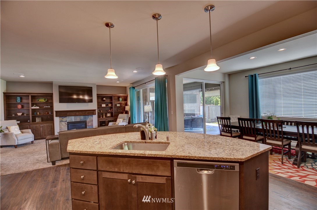 4835 Rosa Court Lacey, WA 98503 - Photo 12 of 40 a kitchen with a sink a center island a dining table and chairs