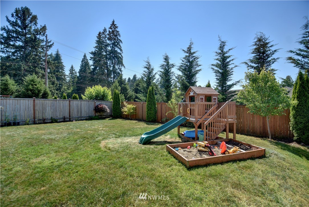 4835 Rosa Court Lacey, WA 98503 - Photo 36 of 40 a view of a backyard with a slide and wooden fence