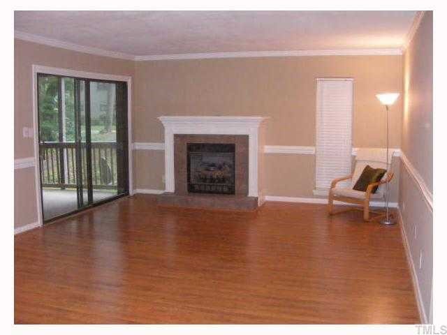 5056 Flint Ridge Place Raleigh, NC 27609 - Photo 3 of 12 a view of empty room with fireplace and wooden floor