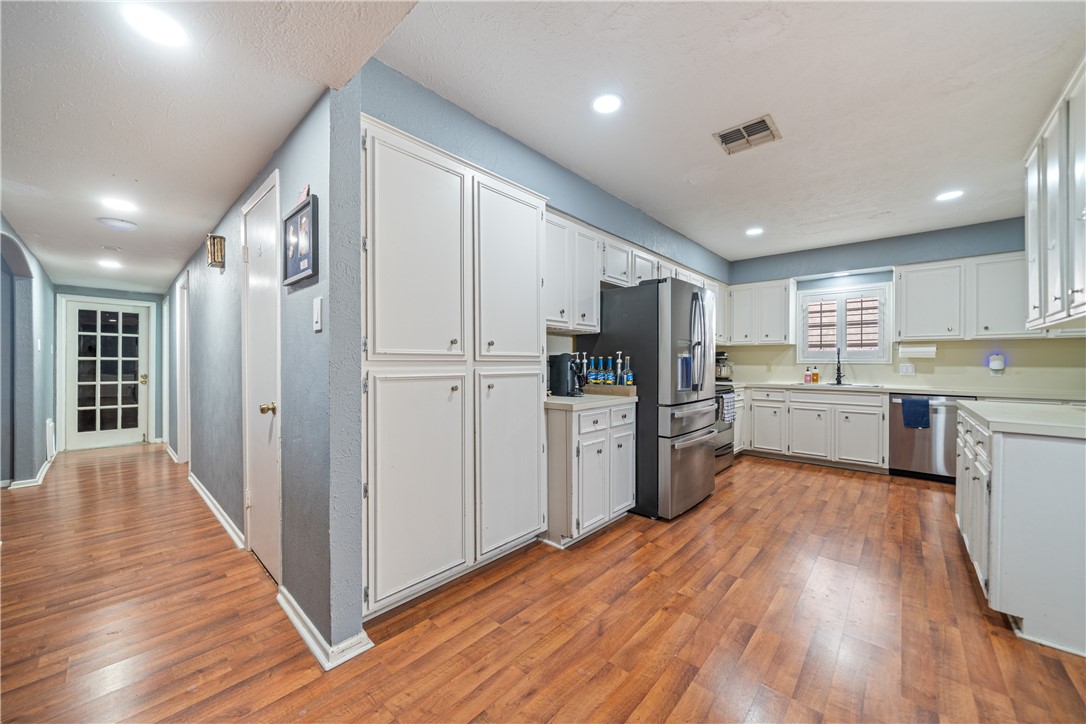 2217 Post Oak Drive Portland, TX 78374 - Photo 8 of 39 a kitchen with refrigerator cabinets and wooden floor
