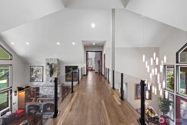 a bedroom with a large bed a flat screen tv and windows