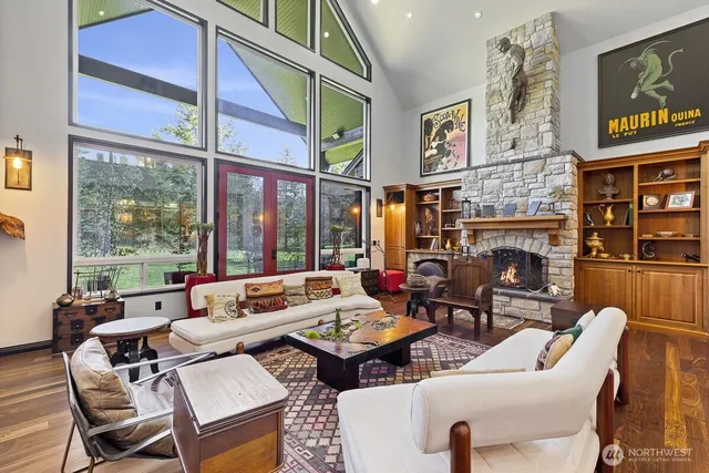 a living room with fireplace furniture and a large window