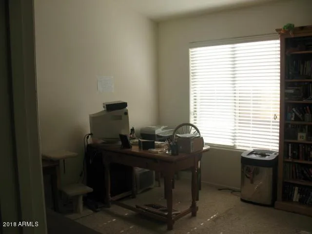 a view of a workspace with furniture and a window