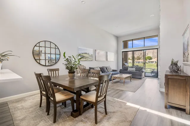 a living room with furniture a flat screen tv and kitchen view