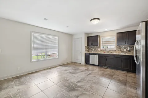a large kitchen with a stove a sink a microwave and cabinets