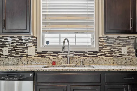 a kitchen with granite countertop a sink and a window