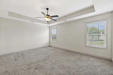 an empty room with a window and a fan