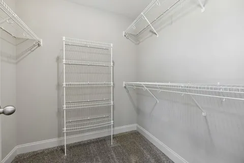 a view of walk in closet with empty racks