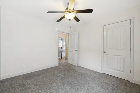 an empty room with closet and fan