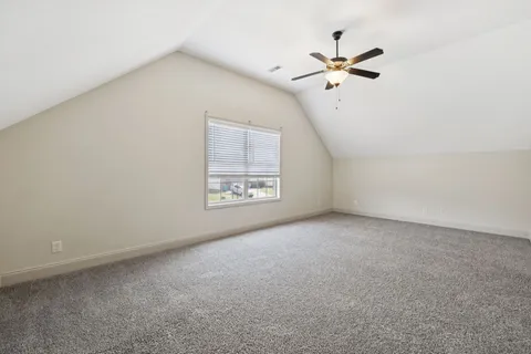 an empty room with fan and windows
