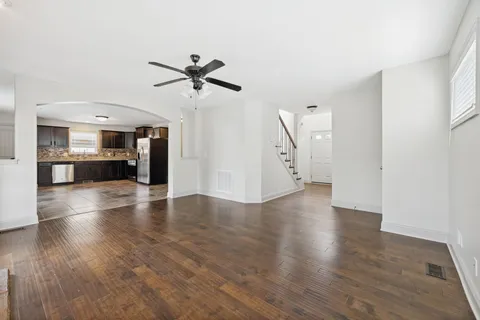 a view of a livingroom with wooden floor and a ceiling fan