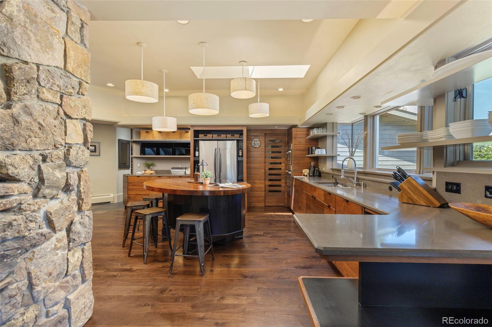 1323 South Snyder Gulch Road Evergreen, CO 80439 - Photo 13 of 47 a large kitchen with a table and chairs