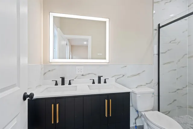a bathroom with a sink vanity and toilet