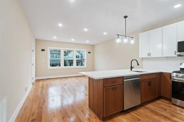 a view of a kitchen counter space a sink wooden floor and appliances