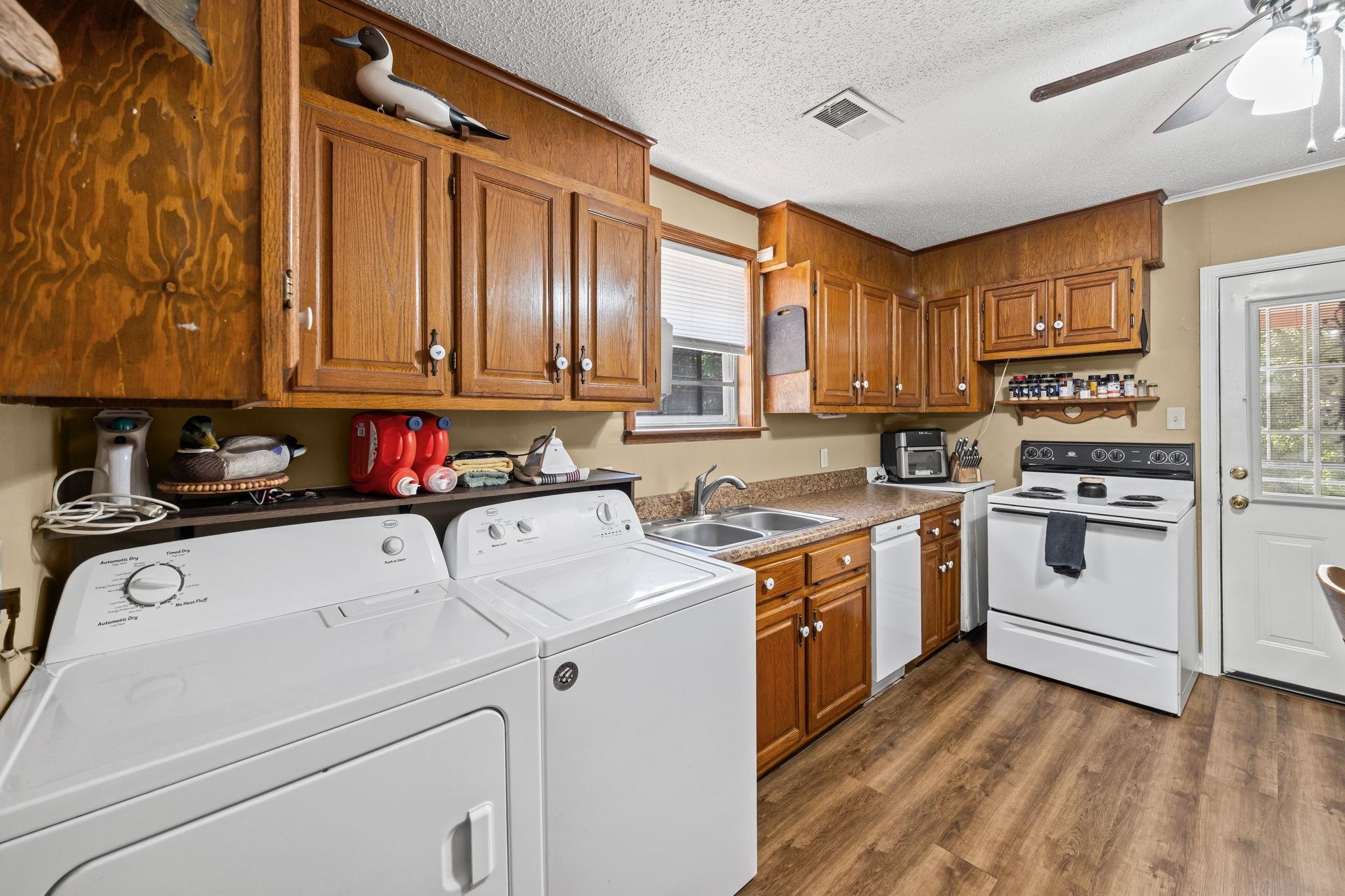 4140 Pleasant Ridge Road Millington, TN 38053 - Photo 14 of 30 Laundry room featuring plenty of natural light, dark wood-style floors, ceiling fan, a textured ceiling, and separate washer and dryer