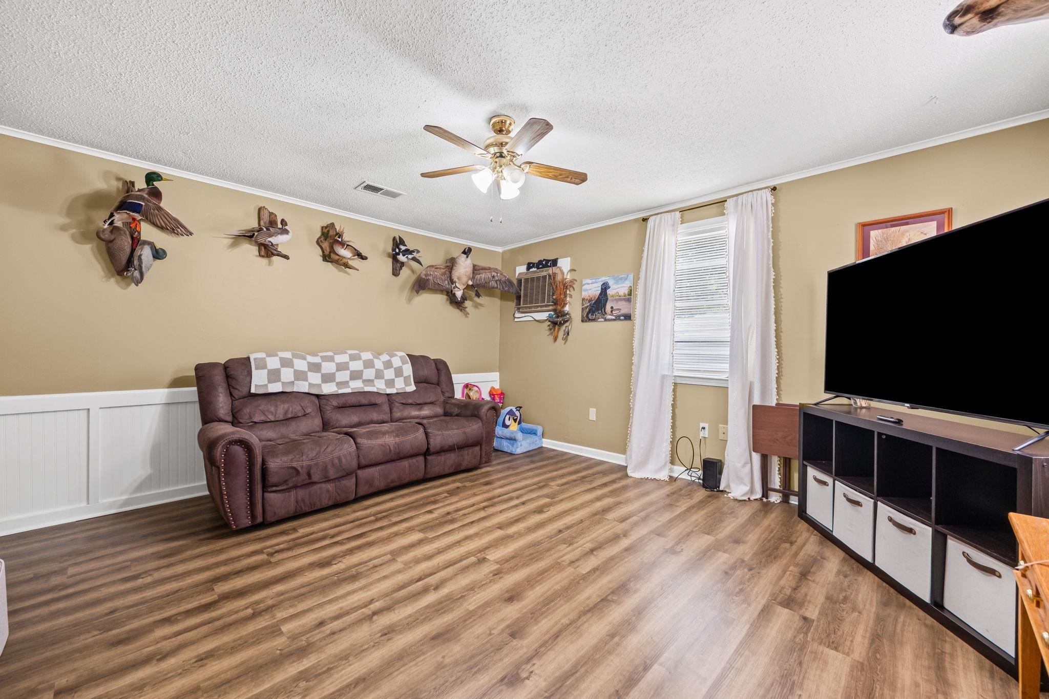 4140 Pleasant Ridge Road Millington, TN 38053 - Photo 2 of 30 Living room with ornamental molding, wood finished floors, a textured ceiling, ceiling fan, and a wall unit AC