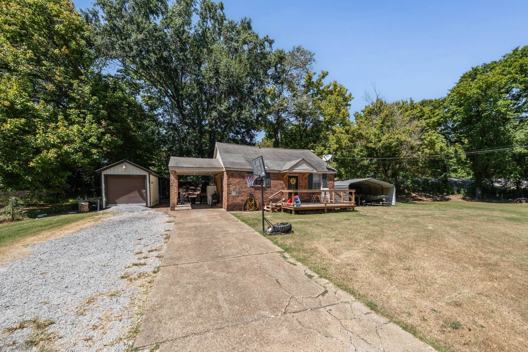 4140 Pleasant Ridge Road Millington, TN 38053 - Photo 23 of 30 Bungalow with driveway, an outdoor structure, view of scattered trees, a front lawn, and brick siding